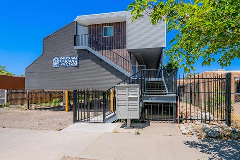 the front of a building with stairs and a gate