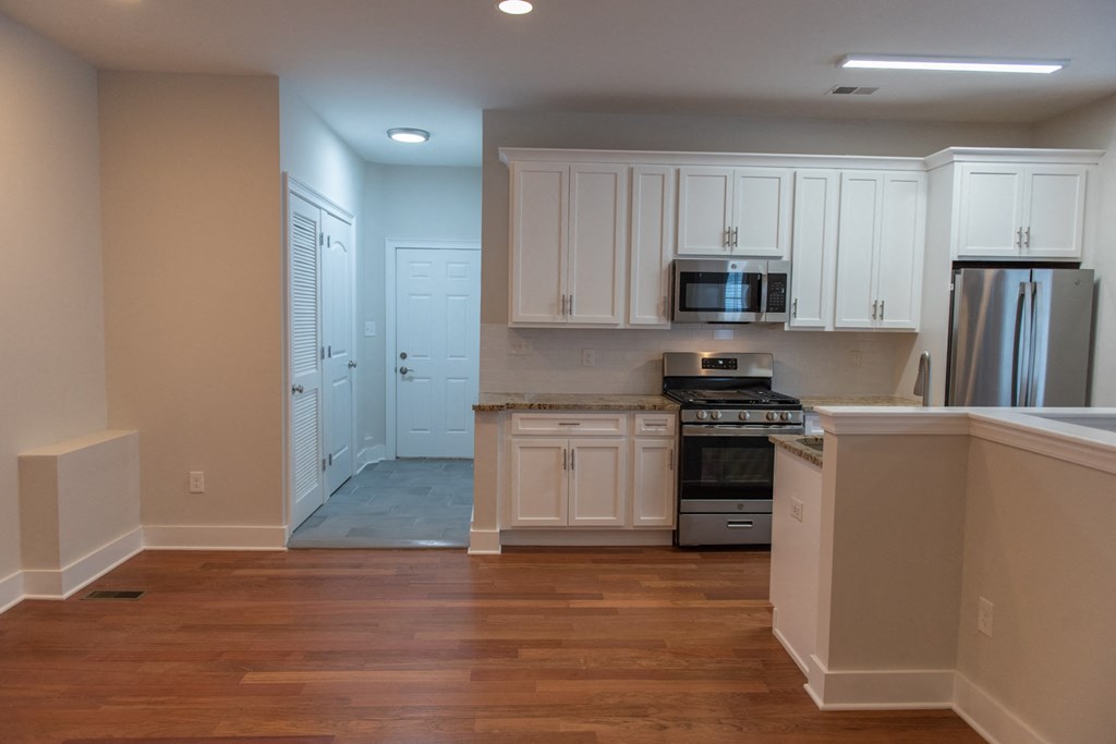 a kitchen with white cabinets and stainless steel appliances