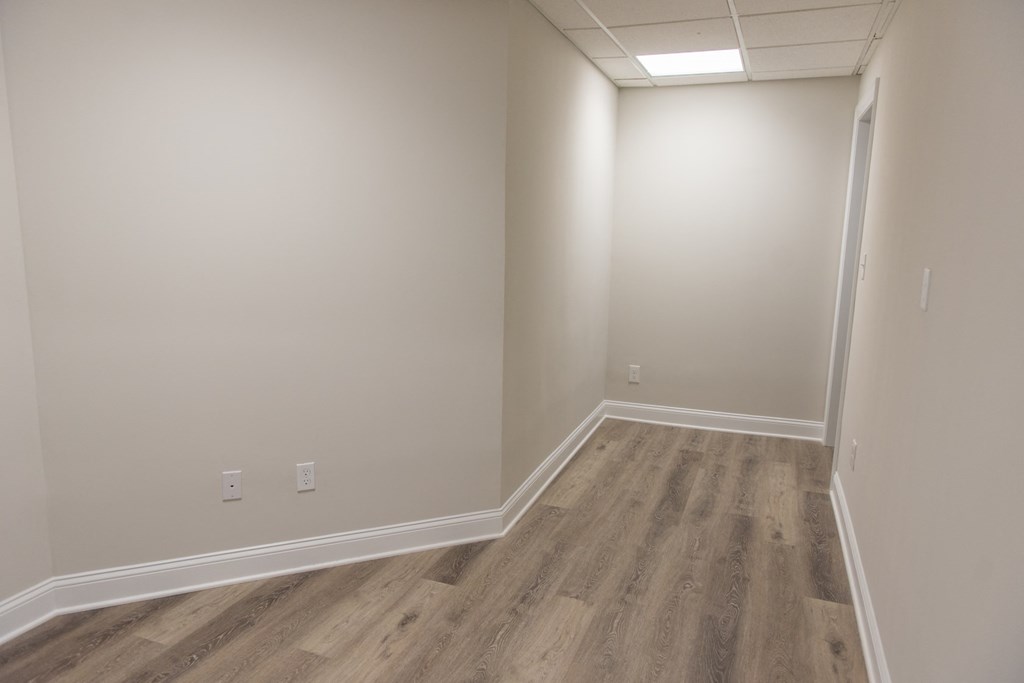 an empty room with wooden floors and white walls