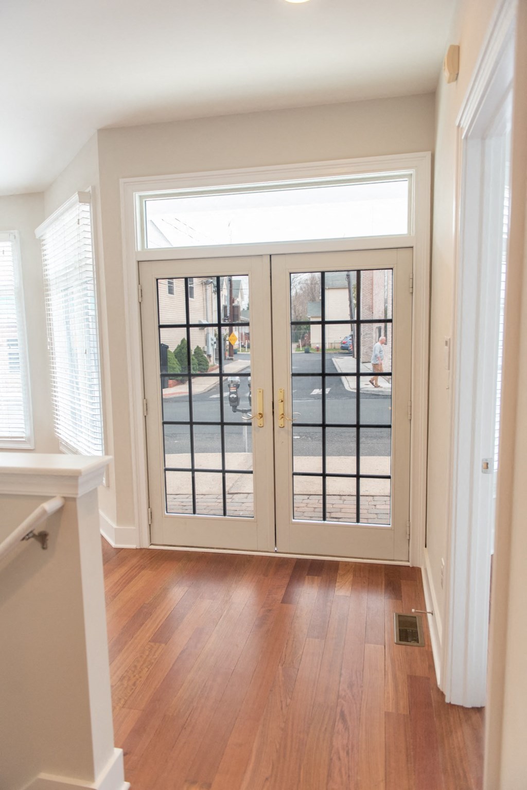 the entryway of a house with a wooden floor and doors
