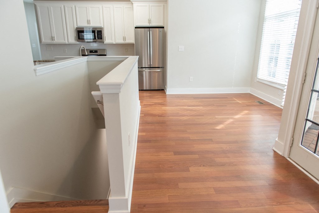 a view of a kitchen and a living room with a hard wood floor