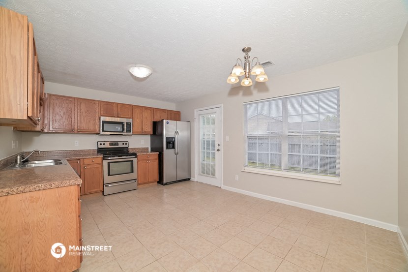a kitchen with wooden cabinets and stainless steel appliances and a large window