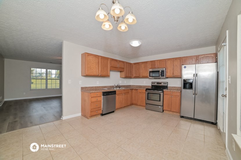 a kitchen with wooden cabinets and stainless steel appliances