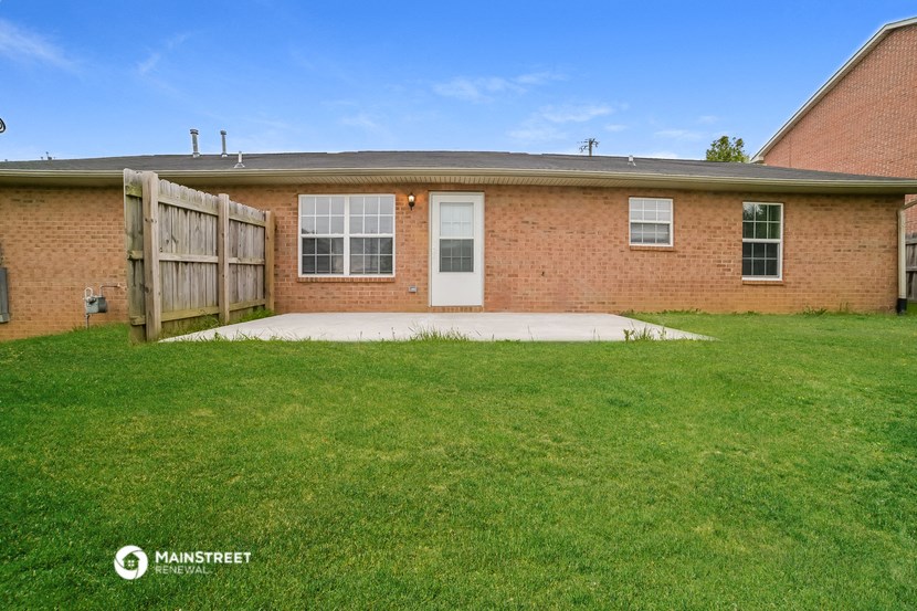 a brick house with a yard and a wooden fence