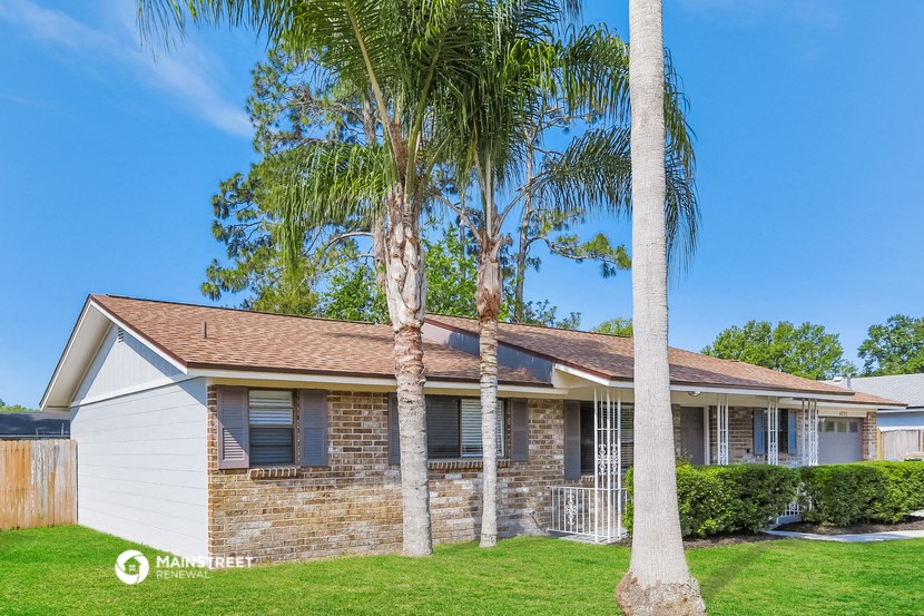 a home with two palm trees in front of it