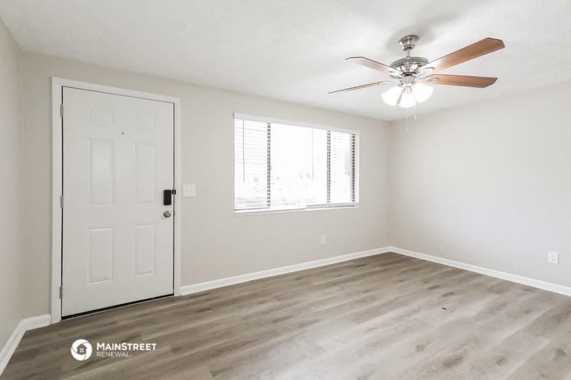 the spacious living room of our studio apartment atrium with ceiling fan and window