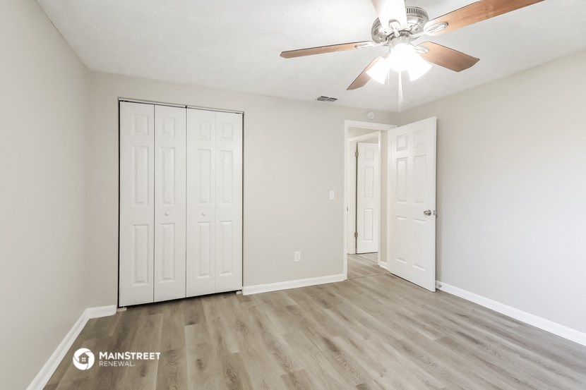 the living room of our studio apartment atrium with white walls and a ceiling fan
