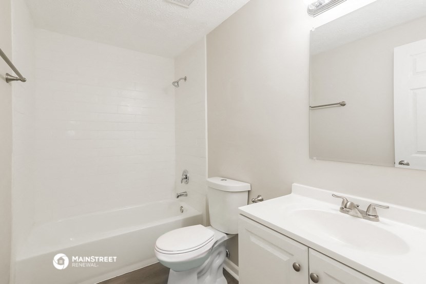 a bathroom with a sink toilet and tub and a mirror