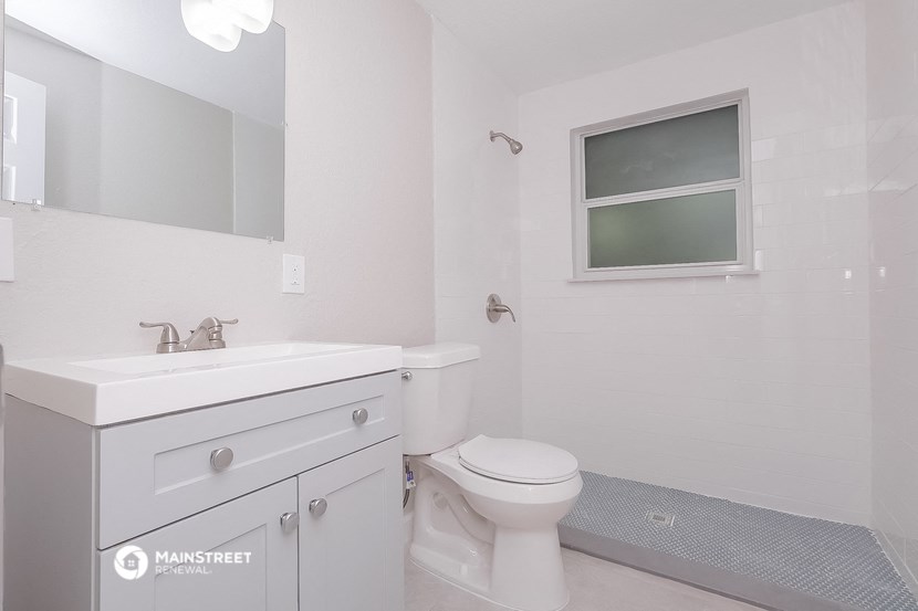 a bathroom with a sink toilet and a mirror