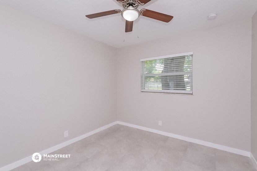 a bedroom with a ceiling fan and a window