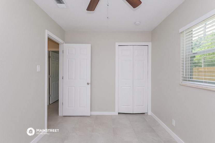 the spacious living room with two doors to the closet