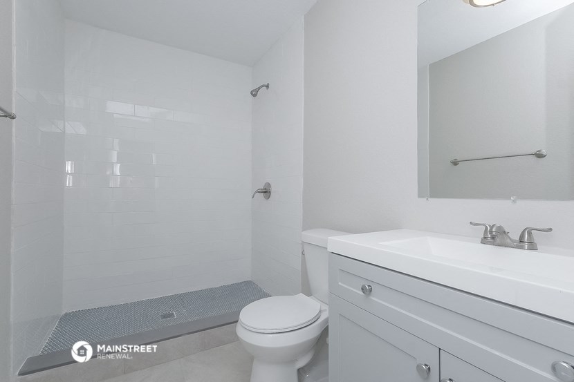 a white bathroom with a sink toilet and shower