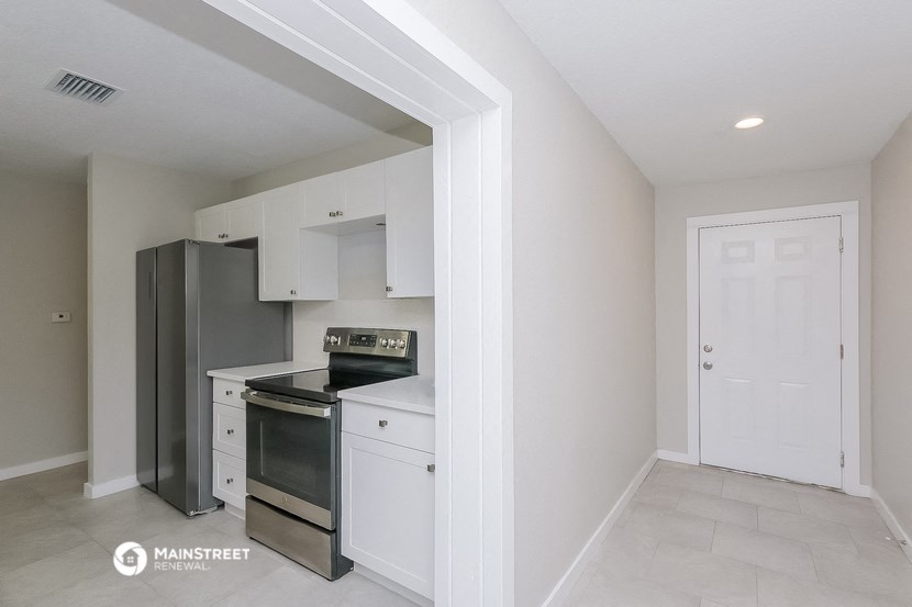 a kitchen with white cabinets and a black stove and refrigerator