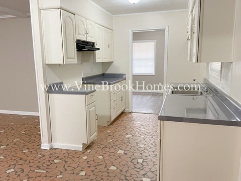 a renovated kitchen with white cabinets and a counter top