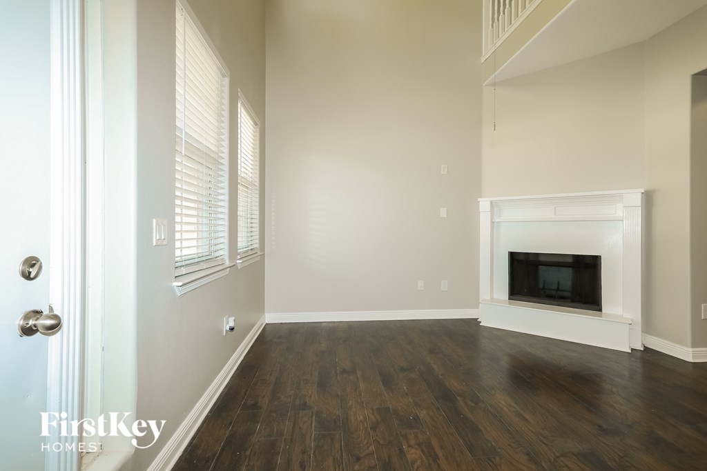 A room with a fireplace and wooden floors.