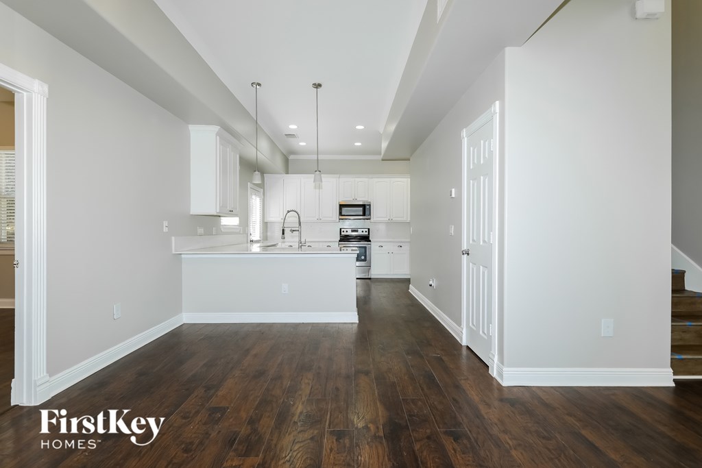 A kitchen with wooden floors and white walls.