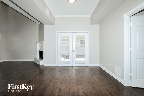 A spacious room with wooden floors and a white door.