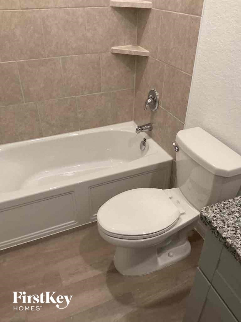 a bathroom with a toilet and a bath tub