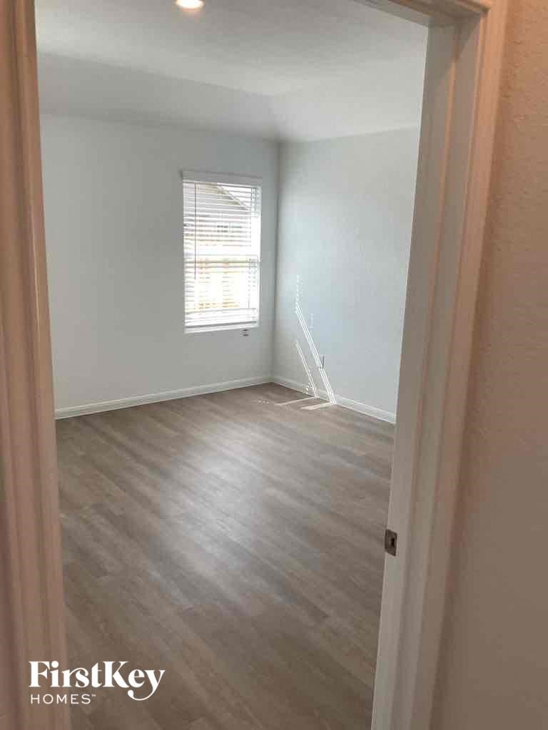 an empty room with white walls and wood floors