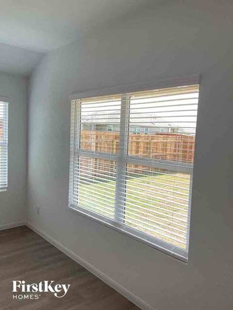 an empty room with a large window with blinds