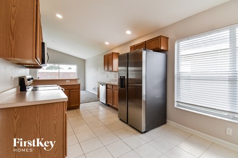 A kitchen with wooden cabinets and a refrigerator.