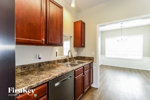 A kitchen with wooden cabinets and a granite countertop.
