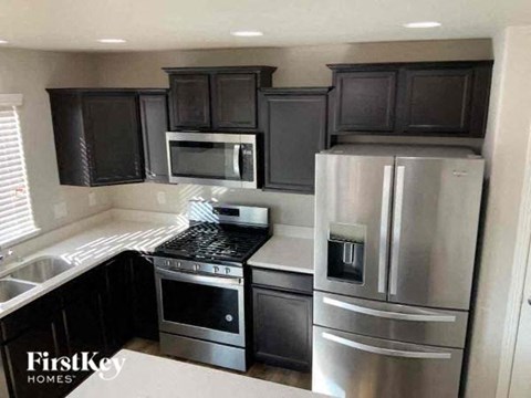 a kitchen with stainless steel appliances and black cabinets