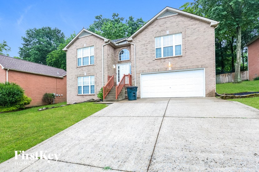 a brick house with a white garage door and a driveway