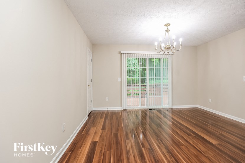 an empty living room with wood flooring and a window