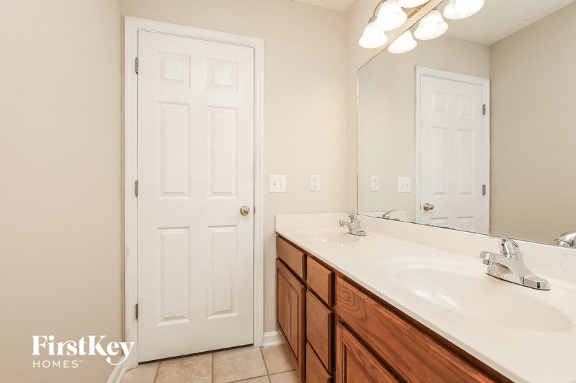 a bathroom with a sink and a mirror and a door