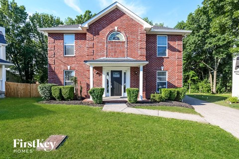 a brick house with a lawn in front of it