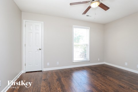 a living room with hardwood floors and a ceiling fan