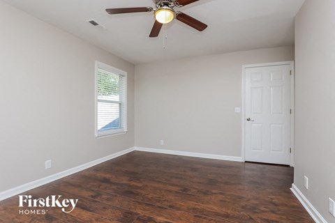 a bedroom with a ceiling fan and a white door