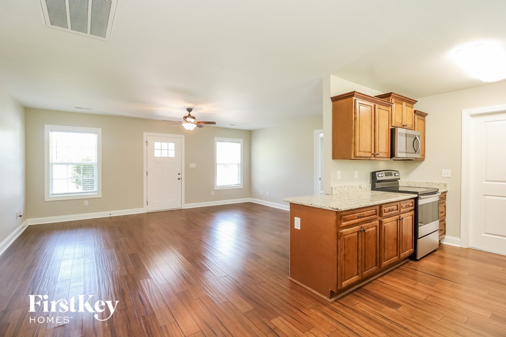 A kitchen with wooden floors and a FirstKey Homes logo.