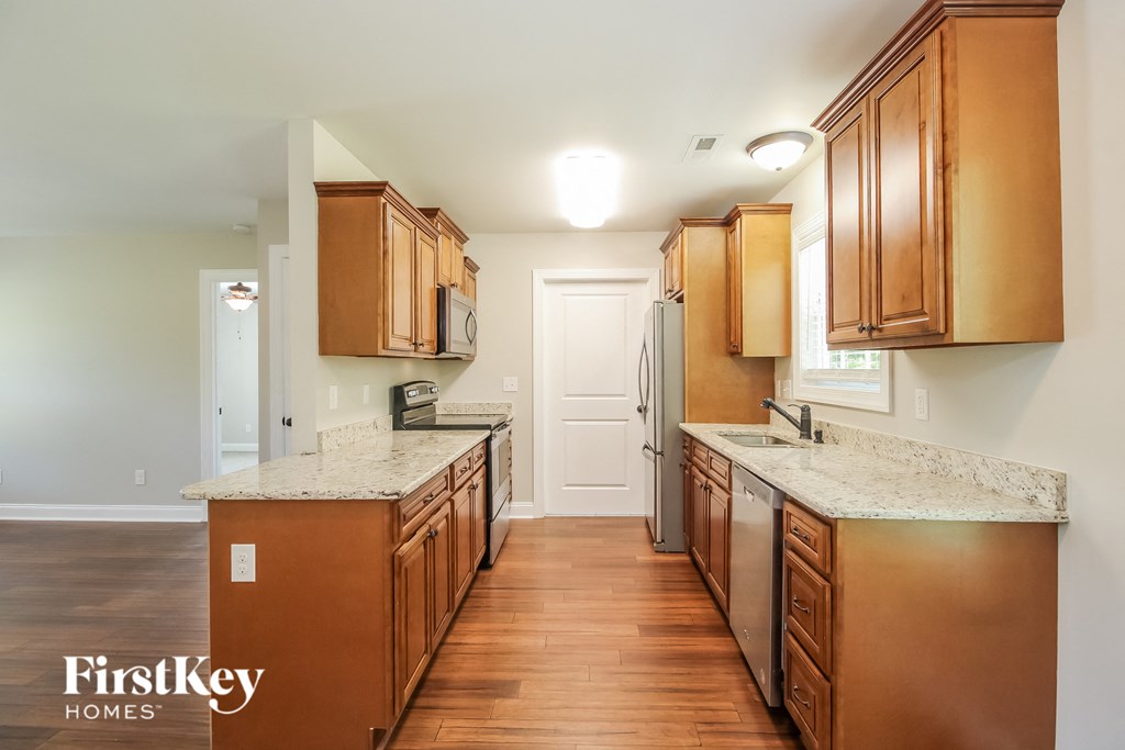 A kitchen with wooden cabinets and a marble countertop.