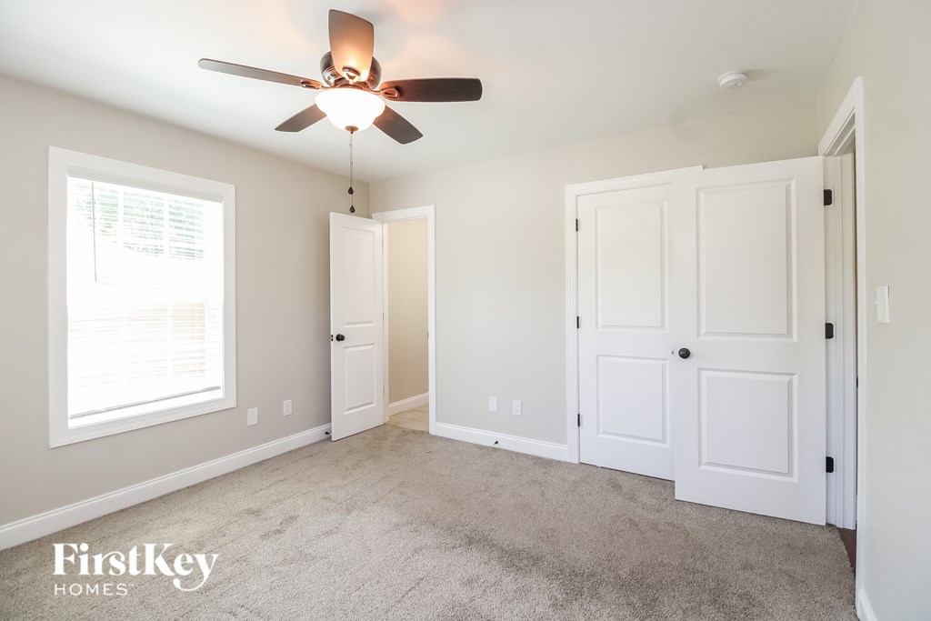 A room with a ceiling fan and two doors.