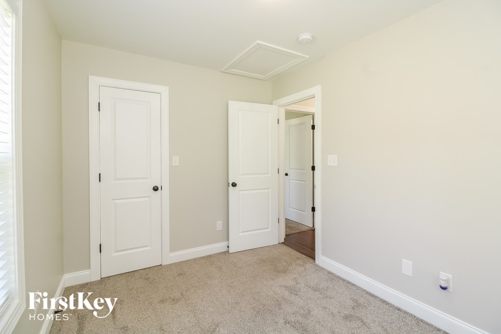A room with two doors and a carpeted floor.