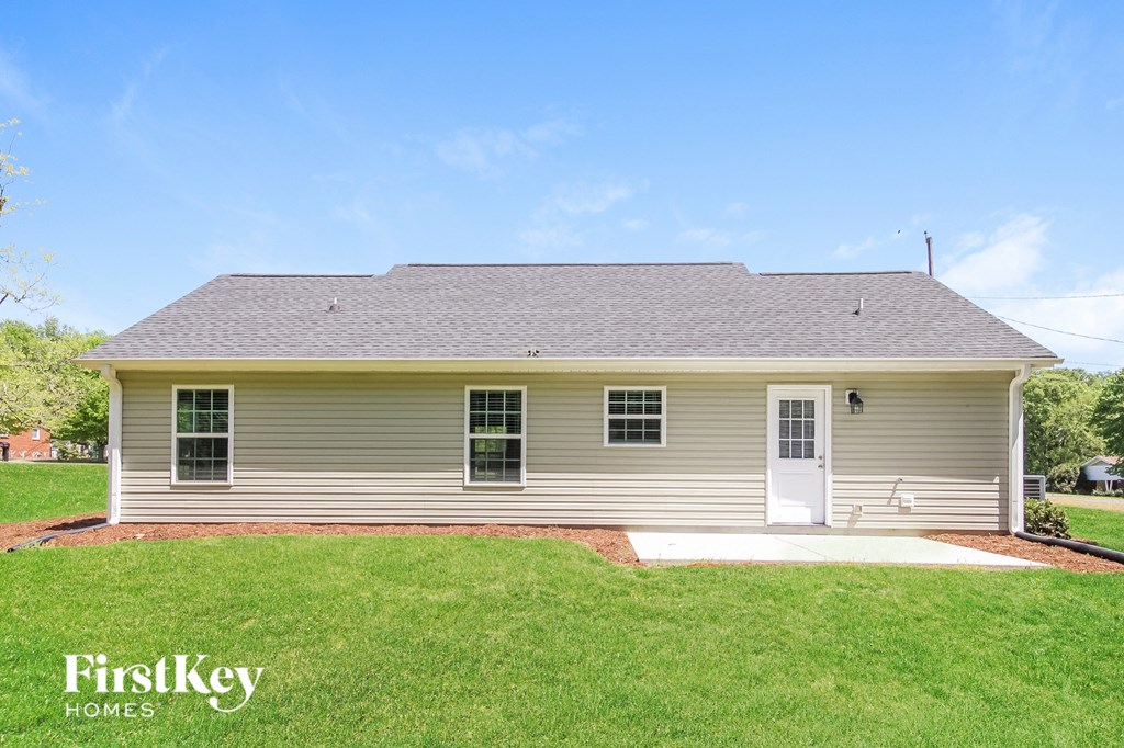 A small house with a grey roof and a white door.