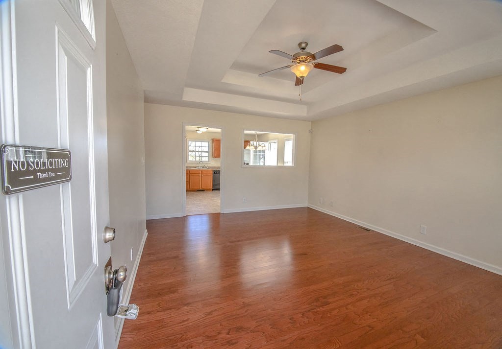 an empty living room with a ceiling fan