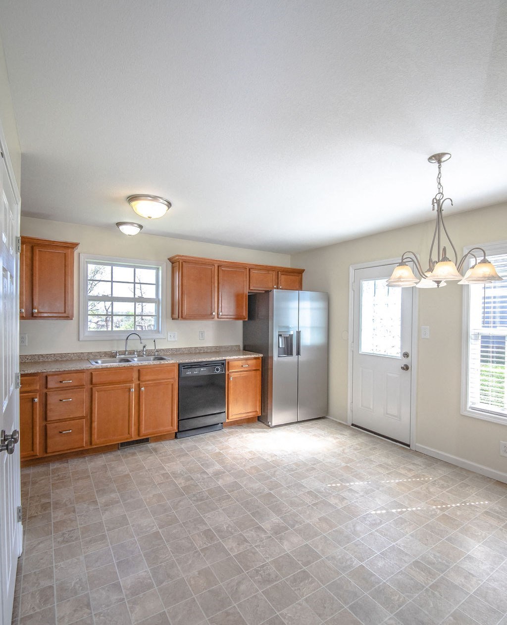 a kitchen with wooden cabinets and a stainless steel refrigerator