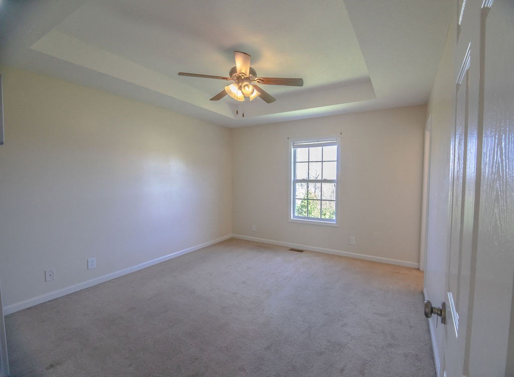 a empty living room with a ceiling fan