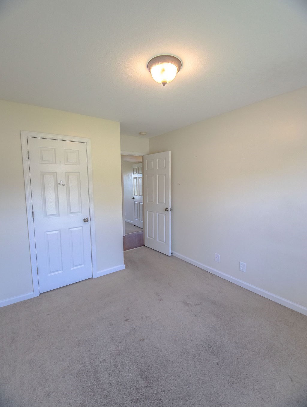 a empty living room with white walls and a white door