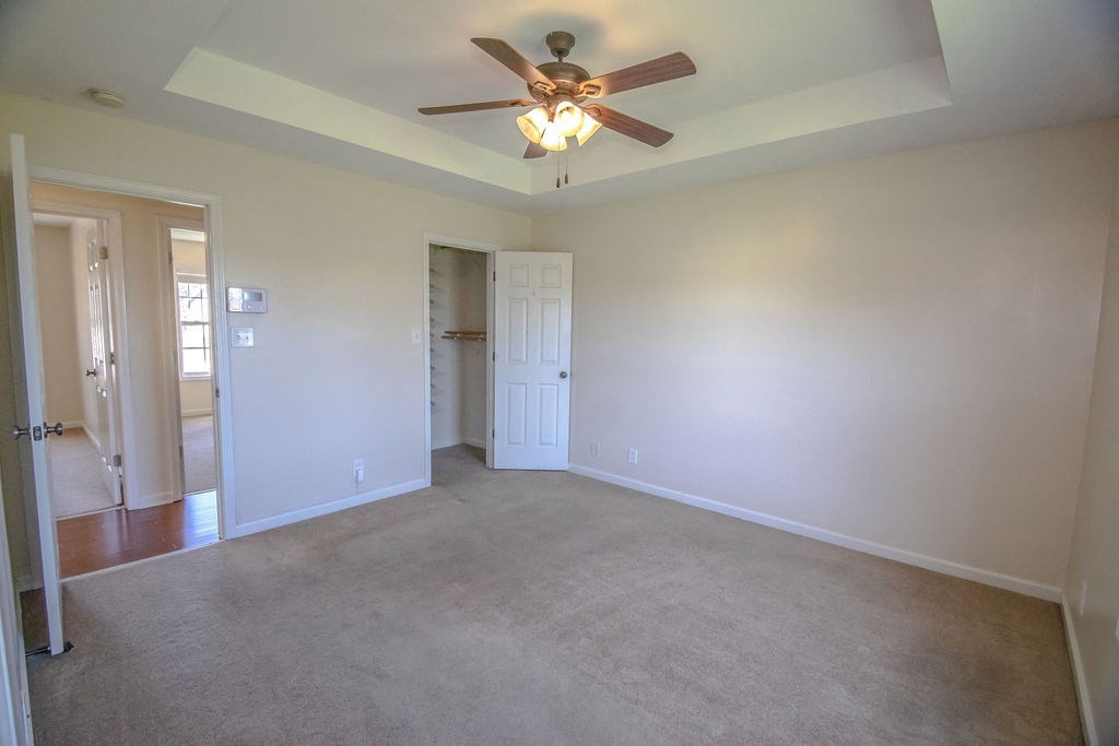 an empty living room with a ceiling fan
