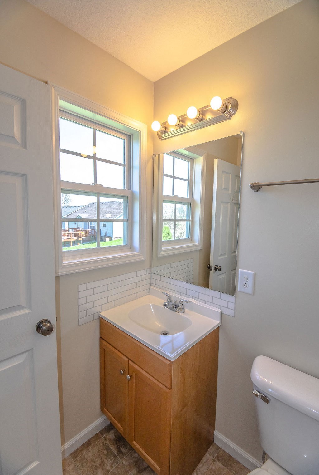 a bathroom with a sink and a mirror and a window