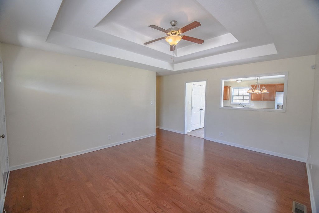 a living room with wood floors and a ceiling fan