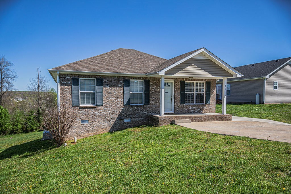 a brick house with a front porch and a lawn