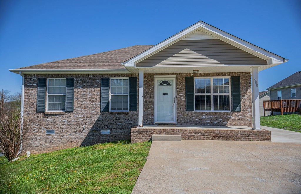 a brick house with a white door and a sidewalk
