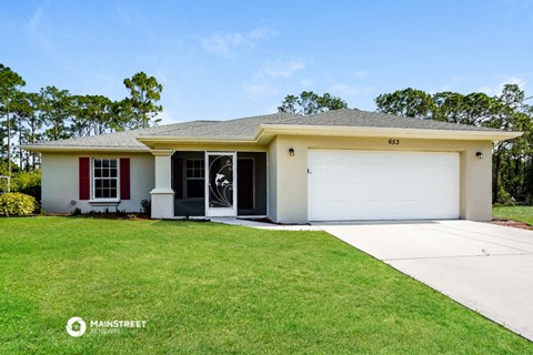 a white house with a lawn and a garage door