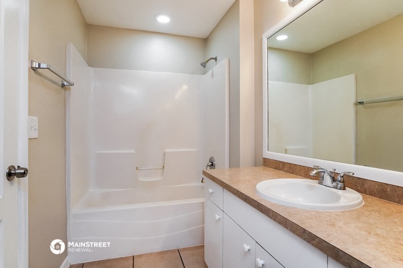 a bathroom with a shower and a sink and a mirror