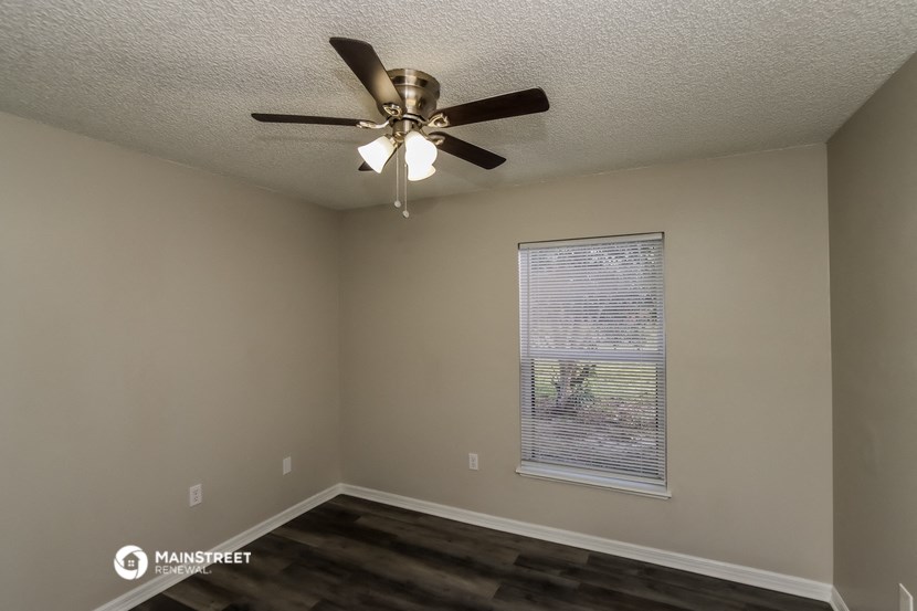 a living room with a ceiling fan and a window
